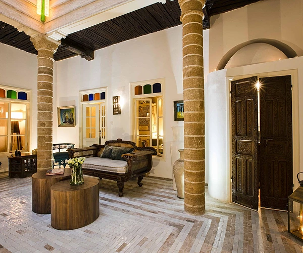 Luxe Riad lounge met decoratieve kolommen en gesneden hout.